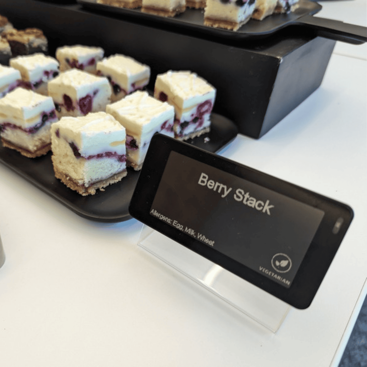 WAND smart label showing Berry Stack with allergens and a vegetarian icon on a dessert tray